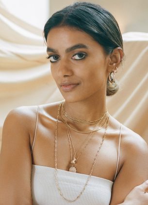 Stella Simona wearing white top and jewellery