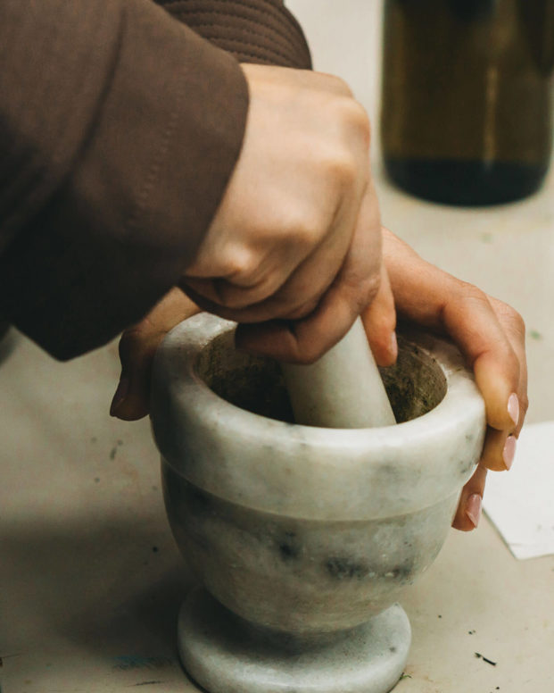 Hands working pestle and mortar